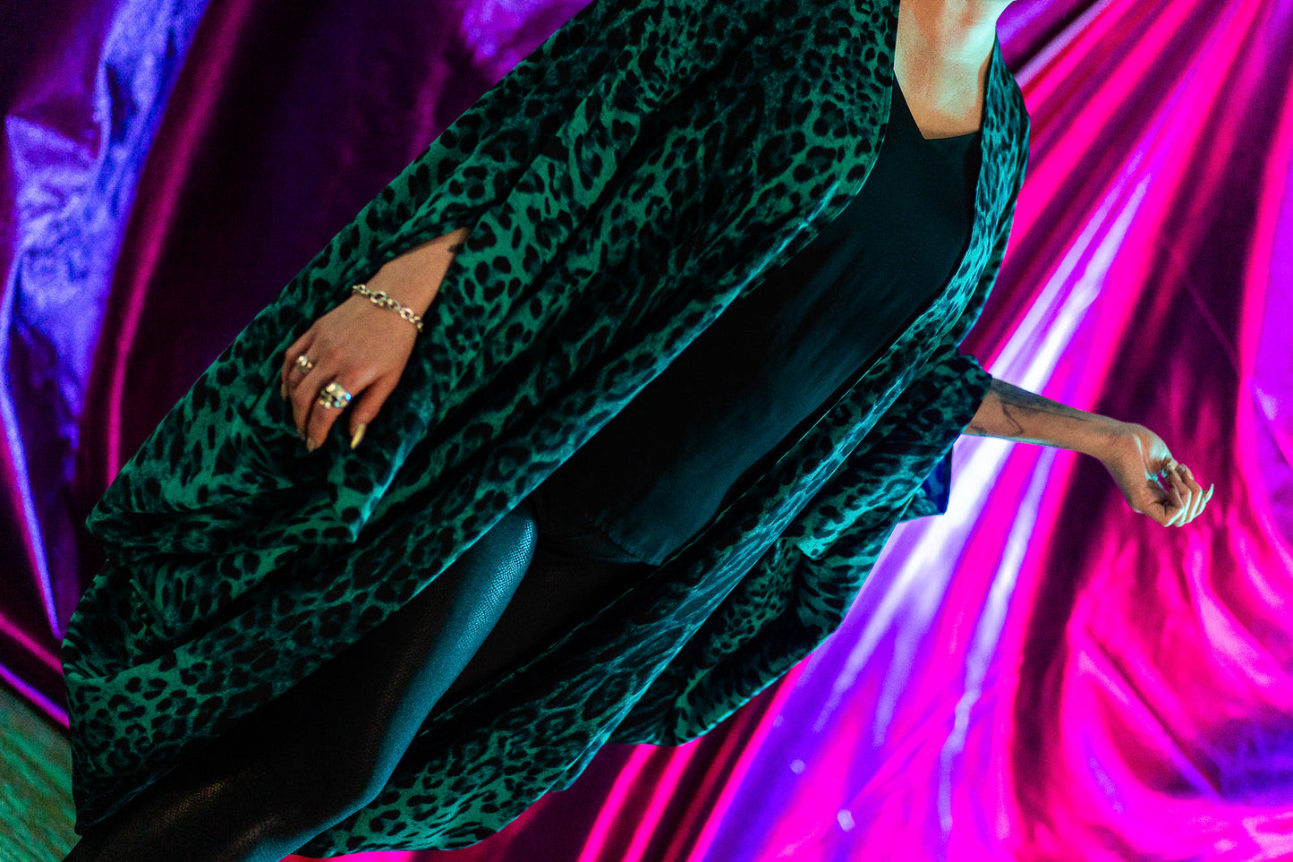 Me modelling the Zubi, in front of a bold pink and purple background with lots of jewellery