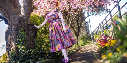 Lindsey in a garden of flowers wearing the oil slick swing dress
