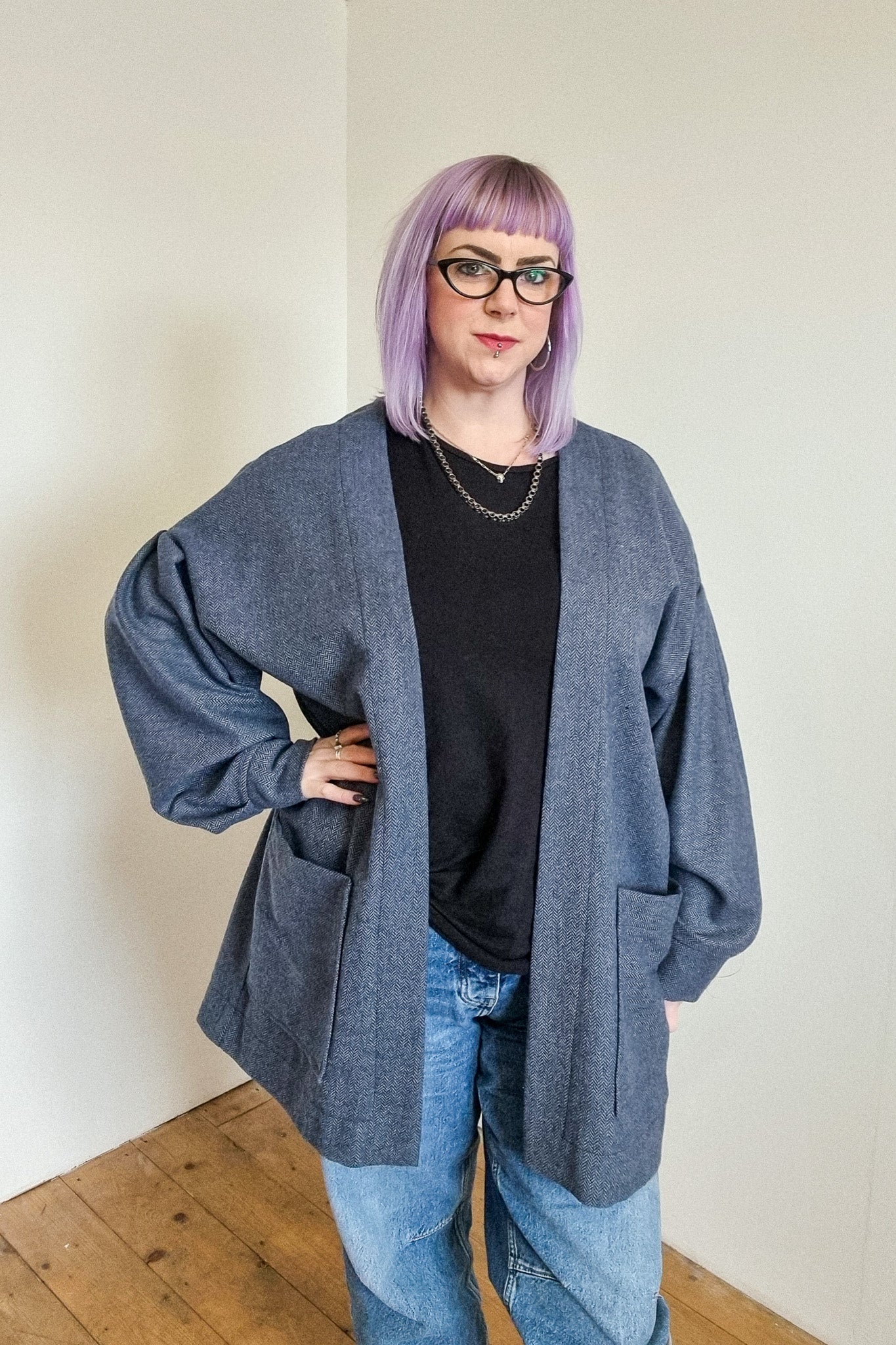 Lindsey the company owner wears the blue herringbone wool cardigan, with large patch pockets, front view