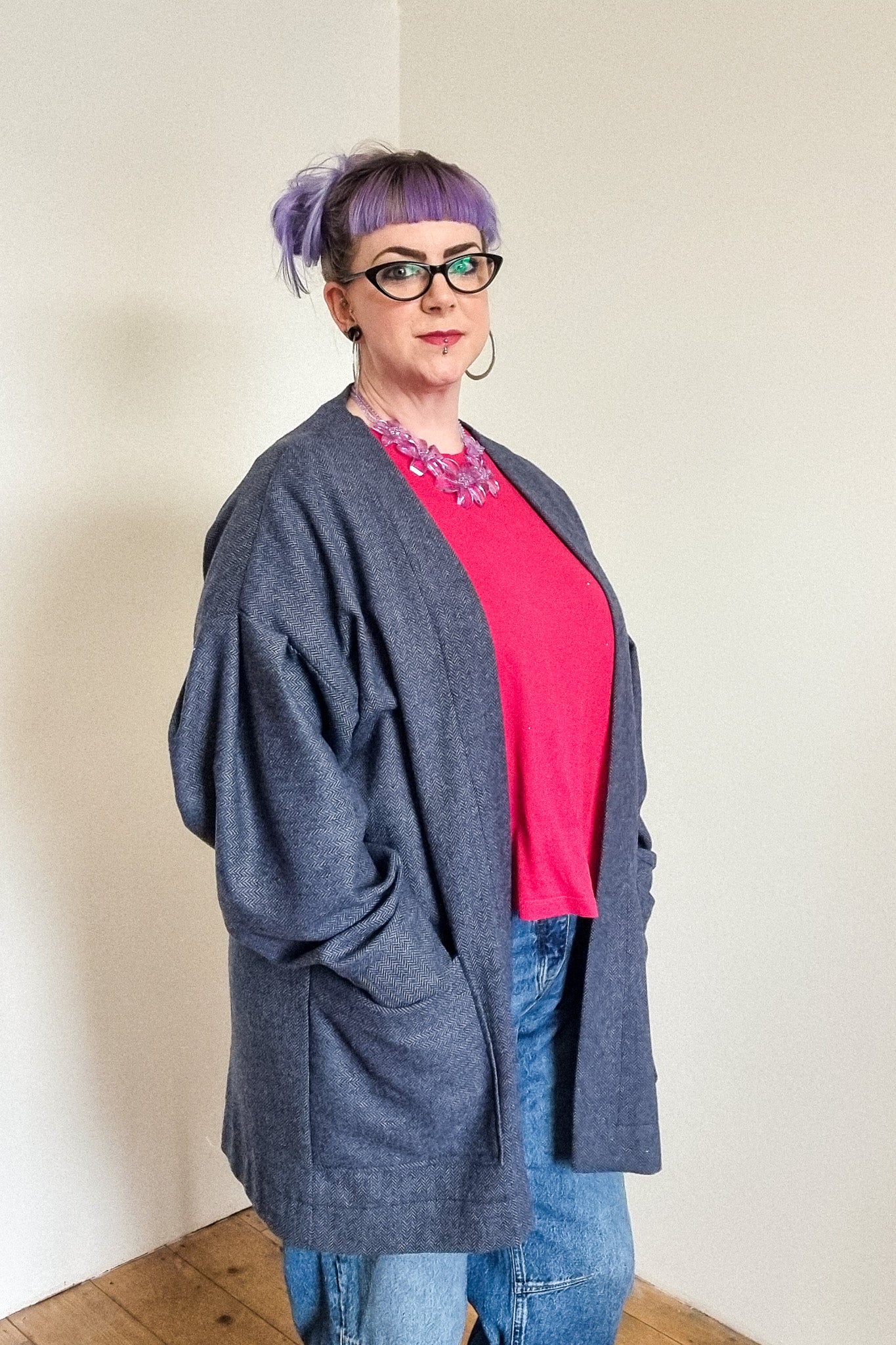 Lindsey the company owner wears the blue herringbone wool cardigan, with large patch pockets, side view