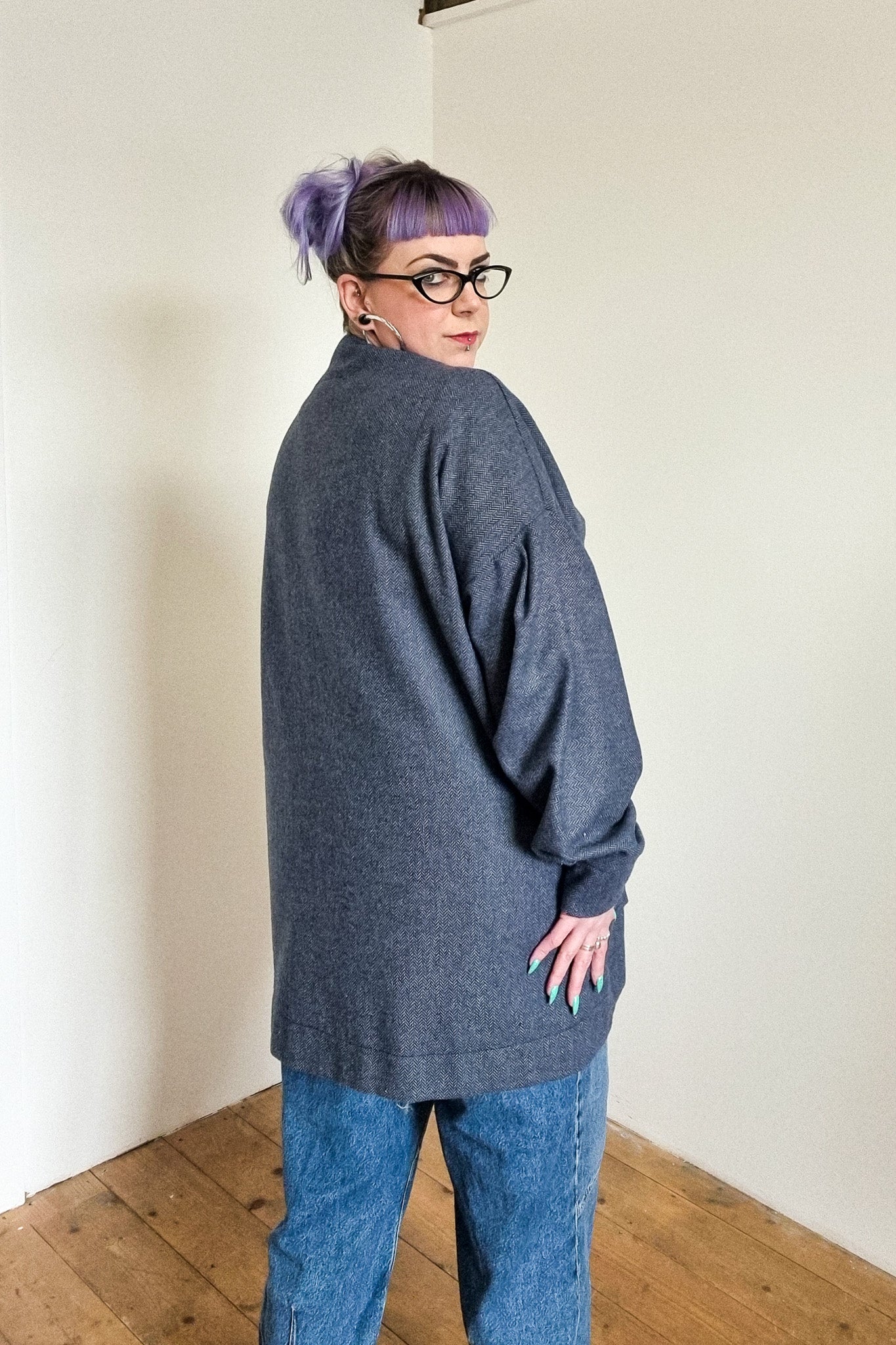 Lindsey the company owner wears the blue herringbone wool cardigan, with large patch pockets, back view