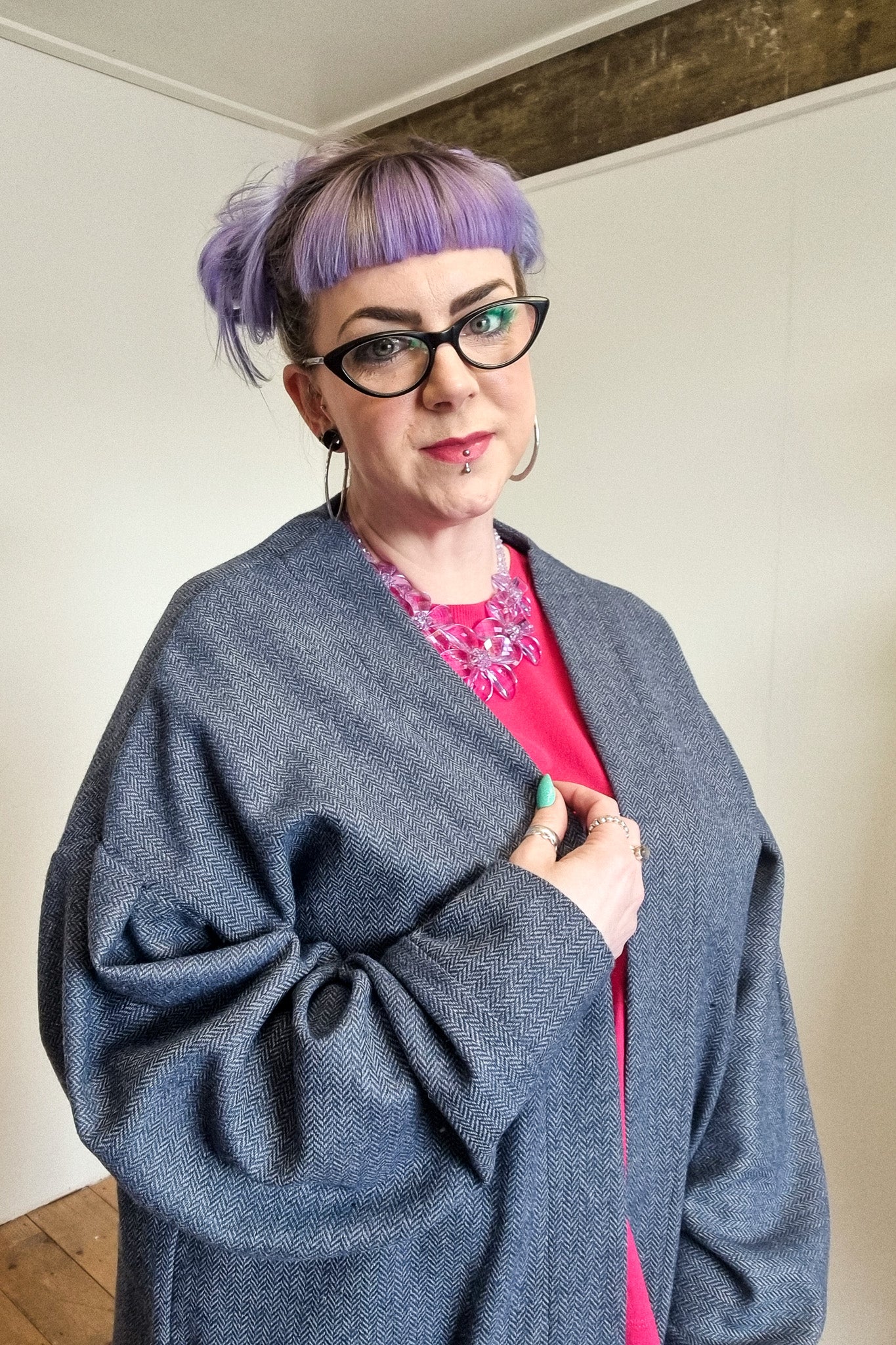 Lindsey the company owner wears the blue herringbone wool cardigan, with large patch pockets, front view up close
