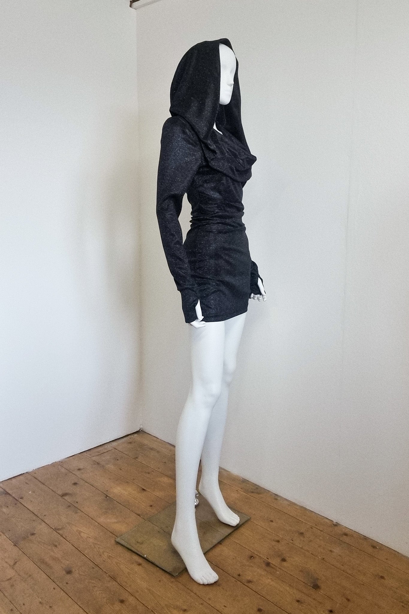 Mannequin wears the black glitter Grace mini with the hood up, side view
