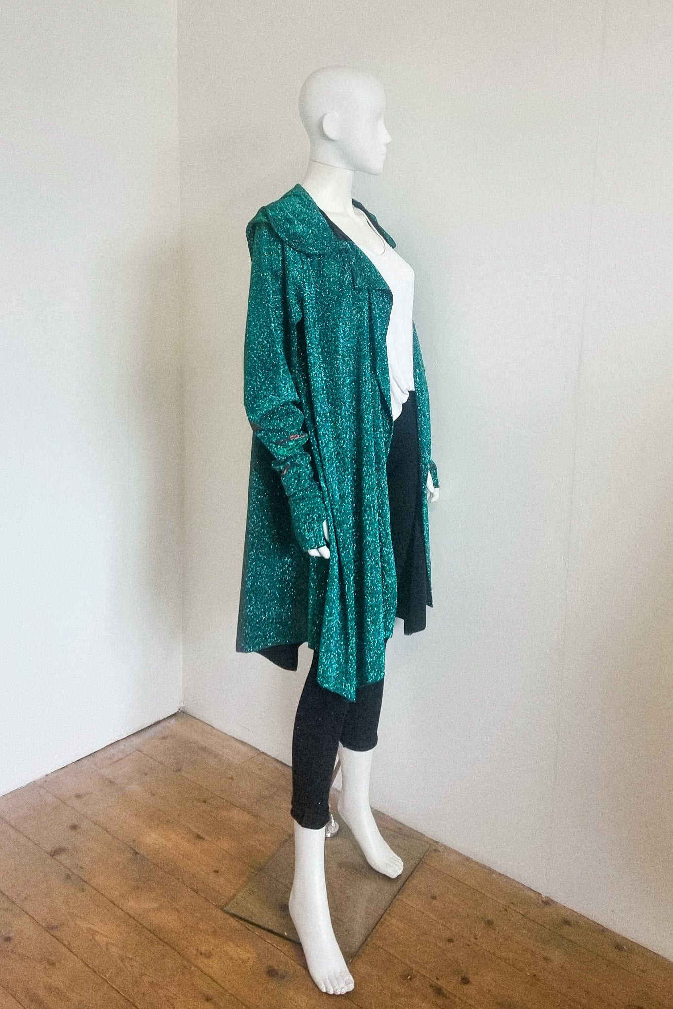 Miho cardigan in green red, photographed on the mannequin, side view with the hood down