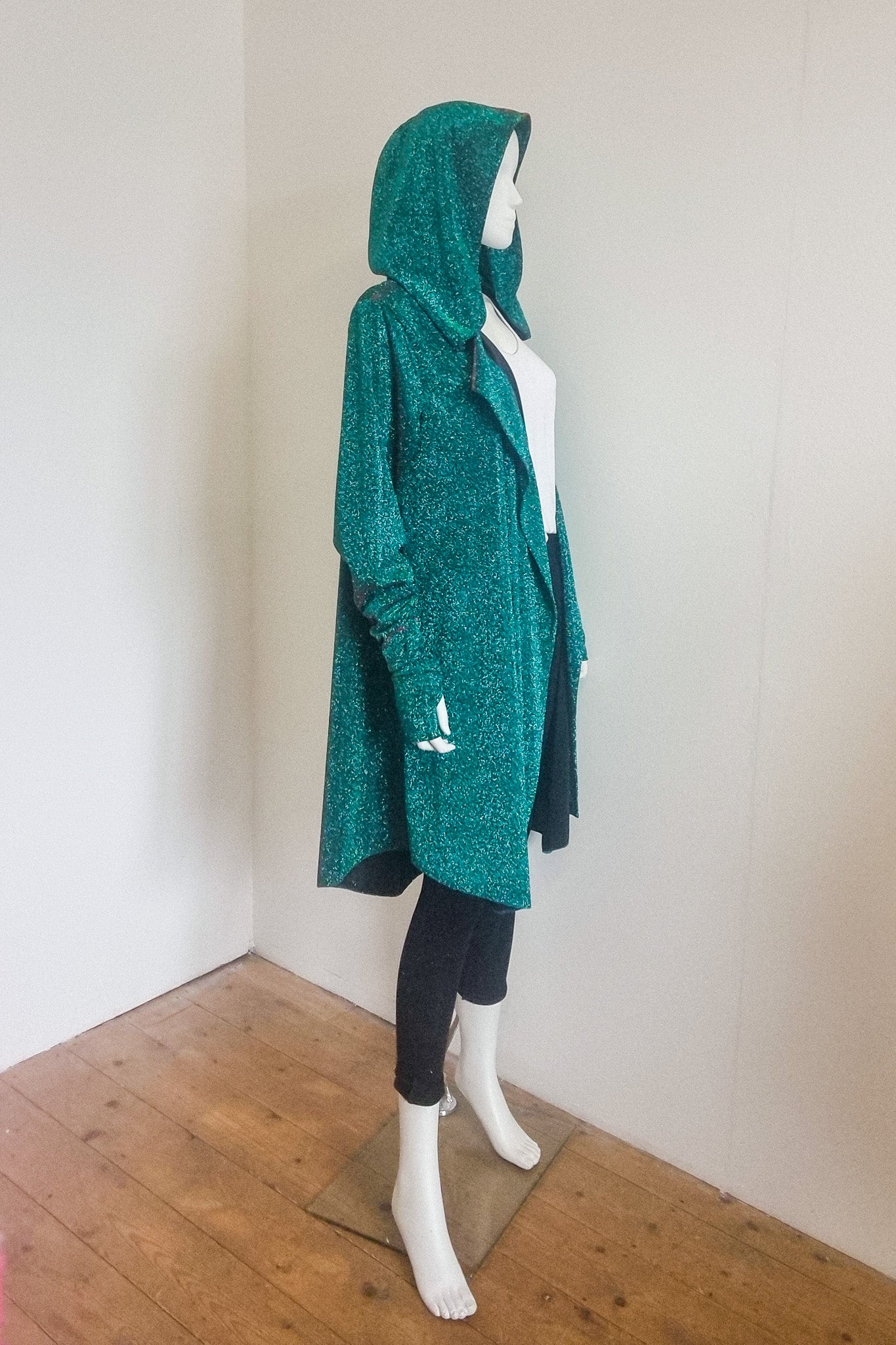 Miho cardigan in green red, photographed on the mannequin, side view with the hood up