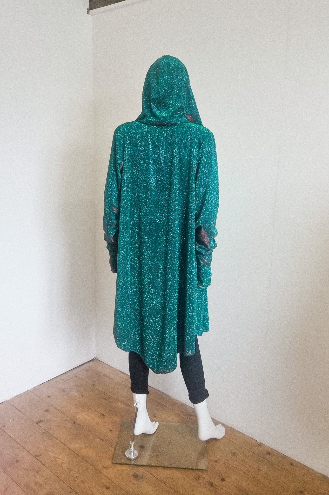 Miho cardigan in green red, photographed on the mannequin, back view with the hood up