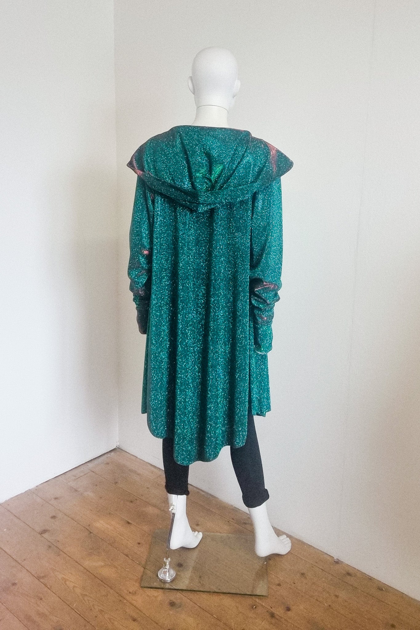 Miho cardigan in green red, photographed on the mannequin, back view with the hood down