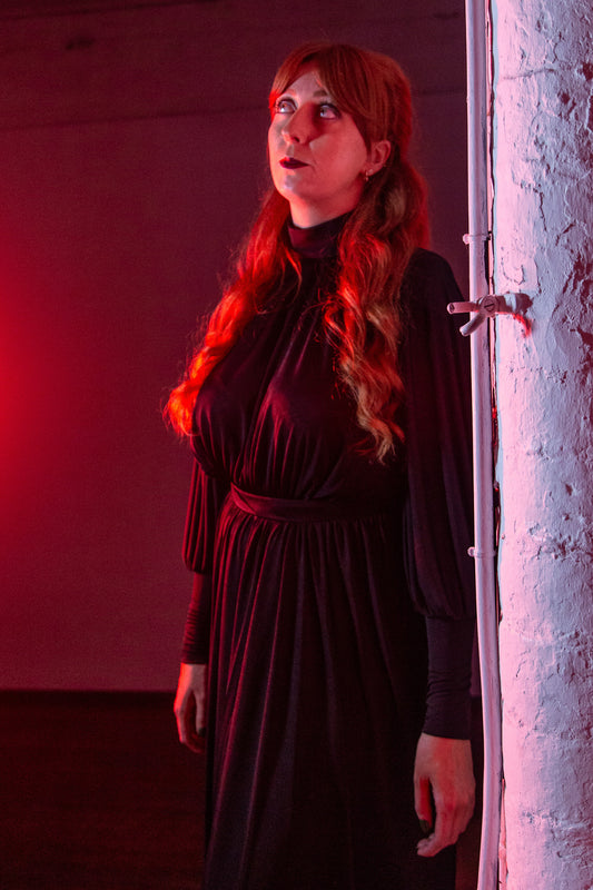 Model Amy wears the black Margaux, photographed in red light.