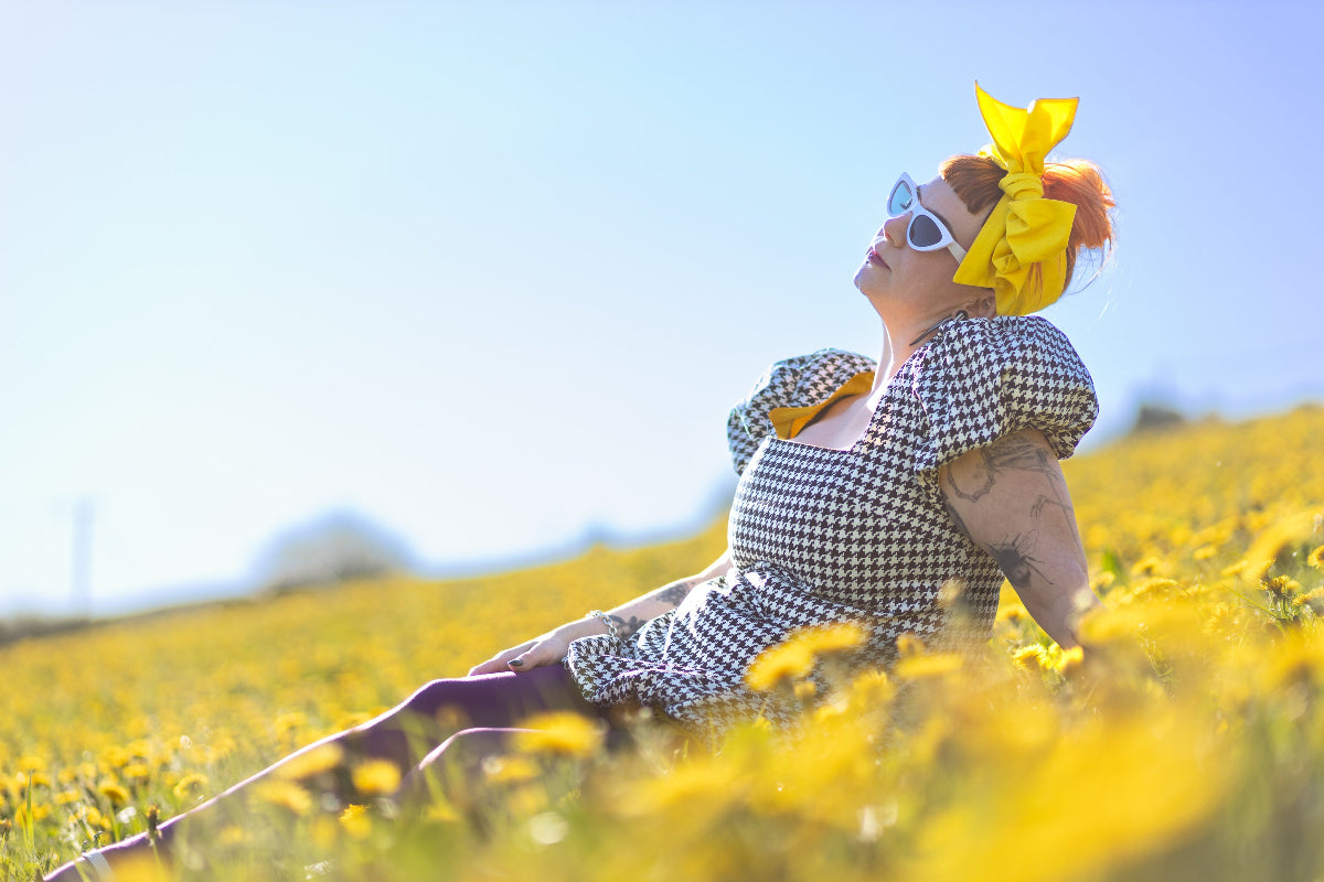 Lindsey wearing a VF dress in a field of dandelions