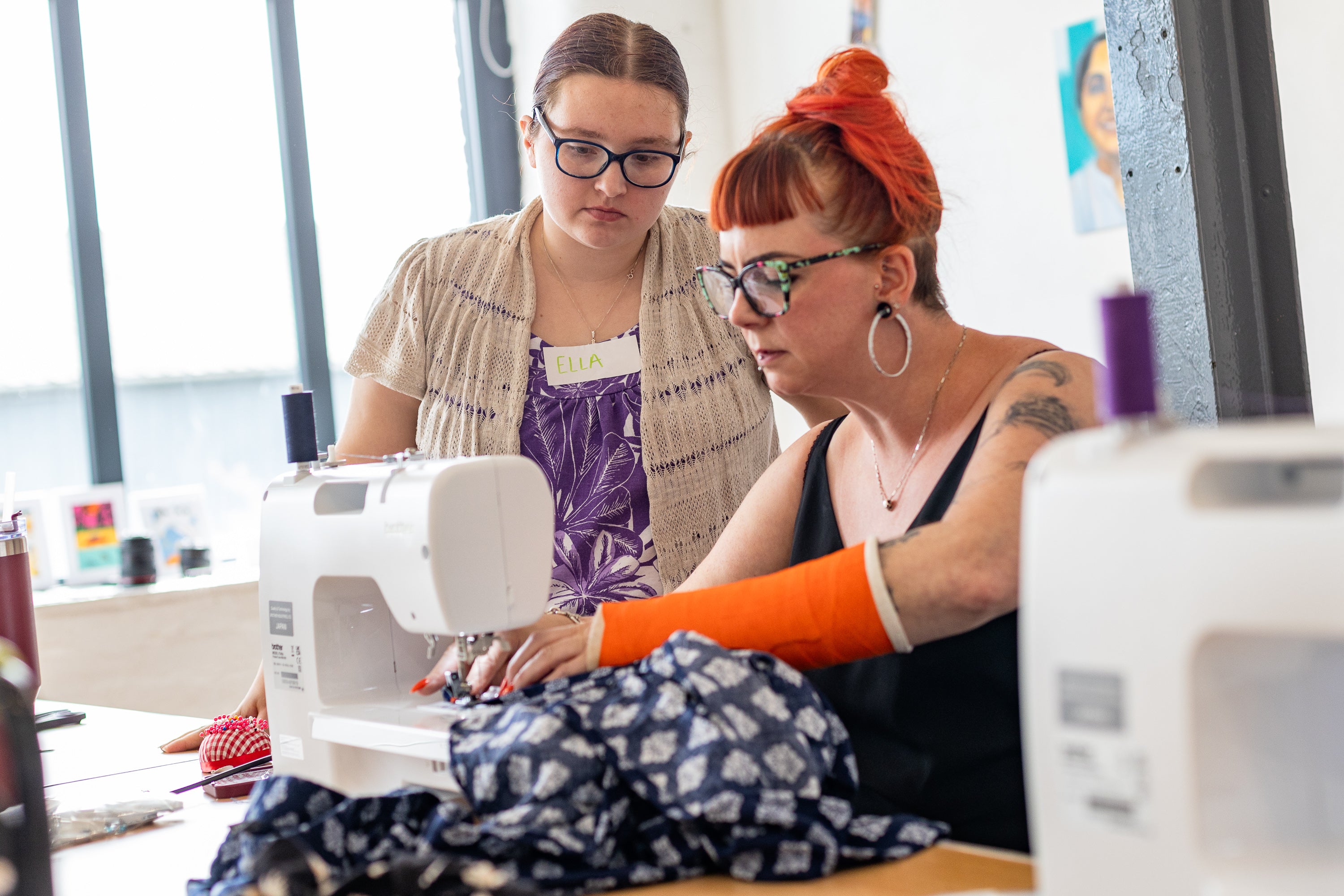 Lindsey showing a student how to upcycle a garment on the domestic sewing machine